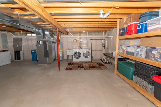 unfinished basement with electric panel, water heater, a sink, heating unit, and washer and dryer