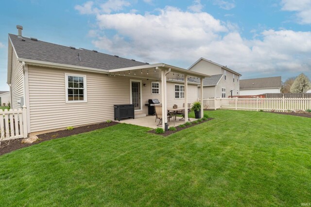 rear view of house featuring a fenced backyard, a patio, and a yard