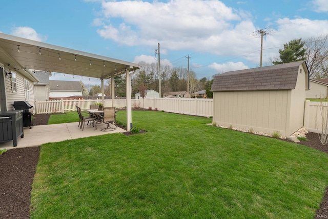 view of yard with an outbuilding, a patio area, a fenced backyard, and a storage shed