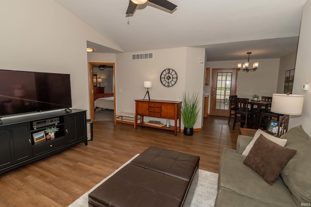 living room with visible vents, ceiling fan with notable chandelier, wood finished floors, and lofted ceiling