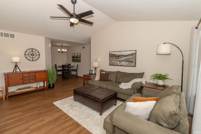 living area featuring ceiling fan with notable chandelier, lofted ceiling, light wood-style flooring, and visible vents