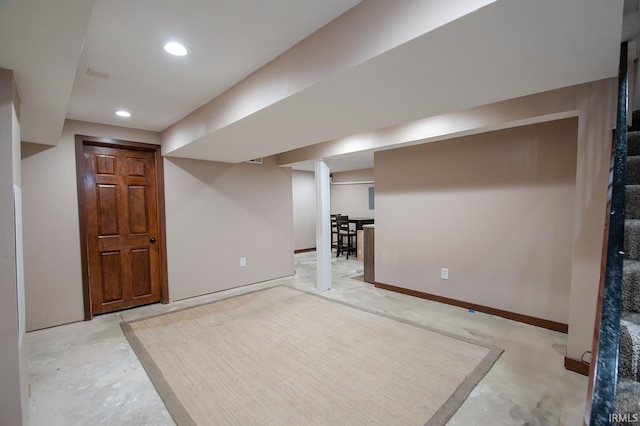 finished below grade area with recessed lighting, baseboards, and stairway