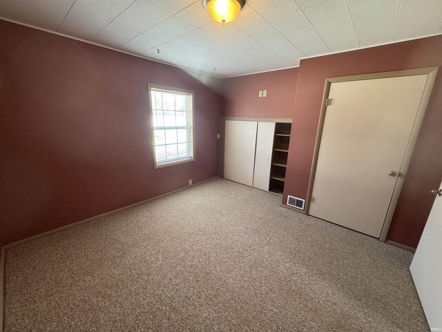 unfurnished bedroom with a closet, carpet flooring, and visible vents