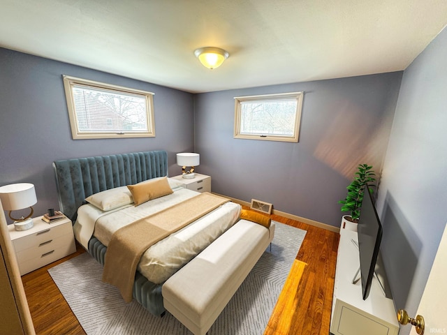 bedroom featuring wood finished floors and visible vents