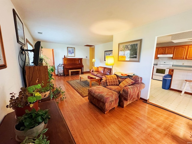 living area featuring light wood-type flooring and visible vents