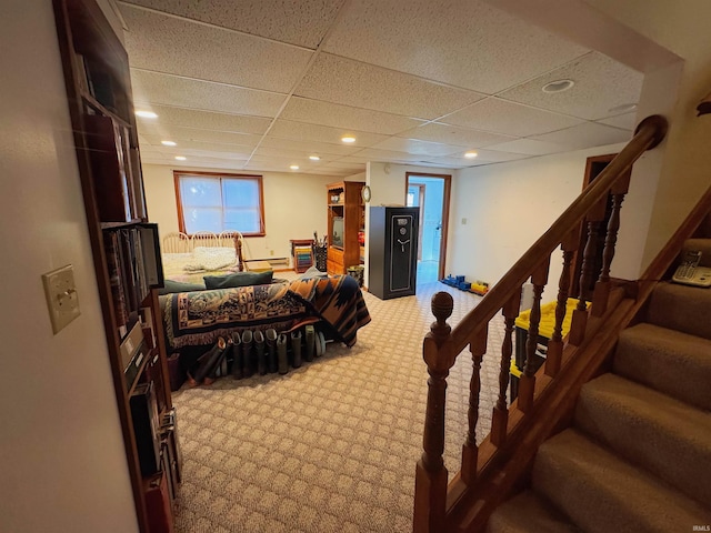 carpeted bedroom with a baseboard radiator, a drop ceiling, and recessed lighting