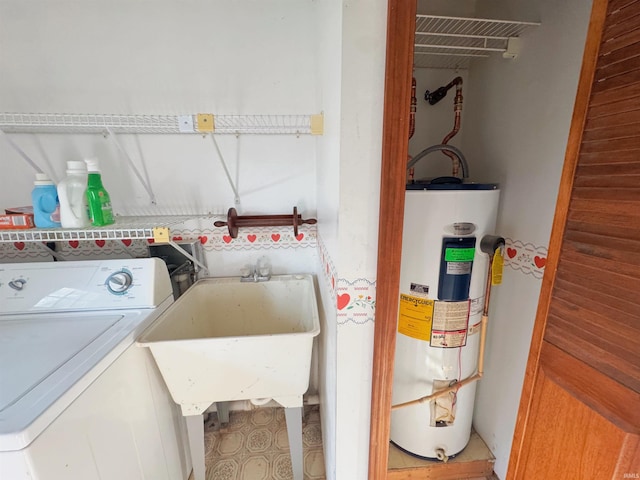clothes washing area with washer / dryer, water heater, laundry area, and a sink