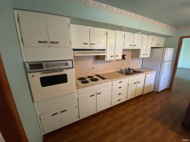 8441 E County Road 650 S, Selma, IN 47383 - kitchen featuring white cabinets, a sink, white appliances, dark wood-type flooring, and under cabinet range hood