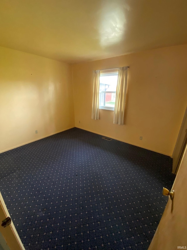 8441 E County Road 650 S, Selma, IN 47383 - unfurnished room with baseboards, dark colored carpet, and visible vents
