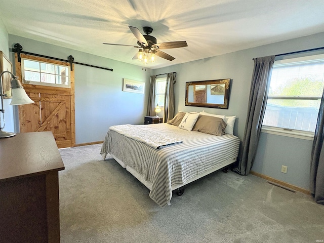 2306 Carmel Dr, West Lafayette, IN 47906 - carpeted bedroom with baseboards, a ceiling fan, a barn door, and visible vents