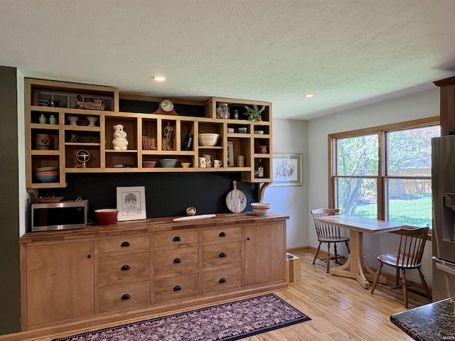2306 Carmel Dr, West Lafayette, IN 47906 - interior space featuring baseboards, a textured ceiling, wood finished floors, and stainless steel appliances