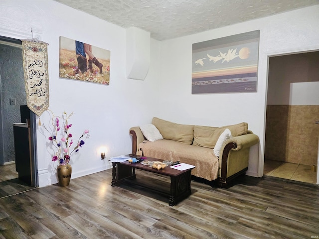 living area with a textured ceiling and wood finished floors