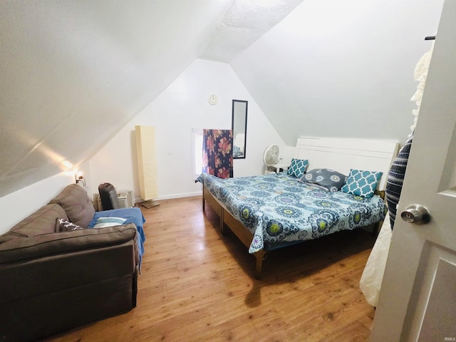 bedroom featuring wood finished floors and vaulted ceiling