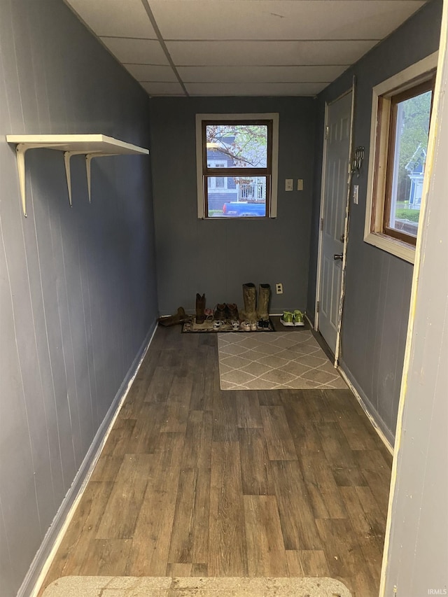 interior space featuring baseboards, dark wood finished floors, and a paneled ceiling