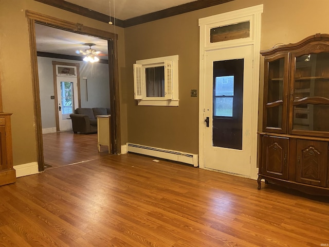 interior space featuring crown molding, a baseboard radiator, a ceiling fan, and wood finished floors