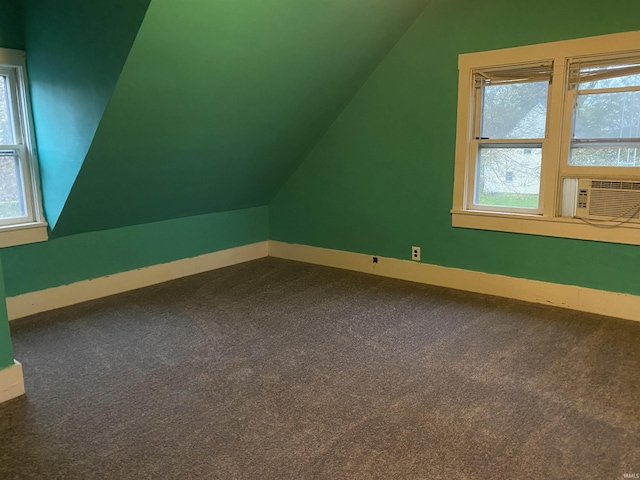 additional living space featuring baseboards, plenty of natural light, cooling unit, and vaulted ceiling