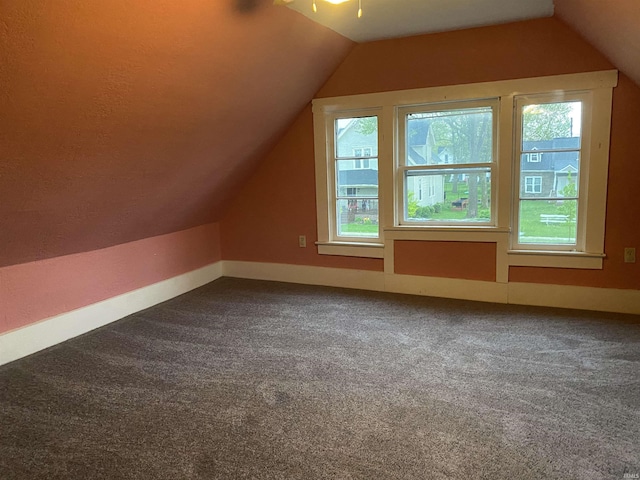 bonus room featuring baseboards, vaulted ceiling, and carpet