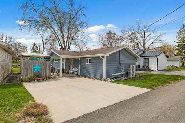 back of house featuring a yard, an outbuilding, and covered porch