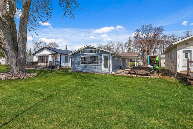 back of property with a lawn and a deck