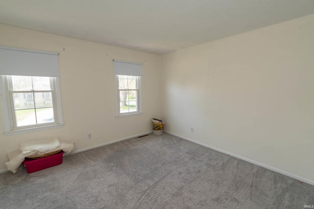 carpeted spare room with baseboards and visible vents