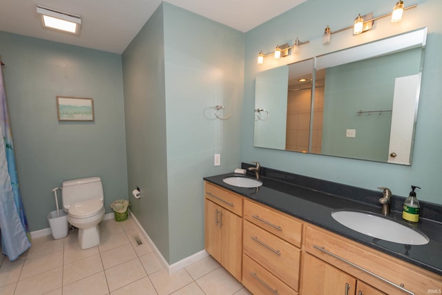 bathroom with tile patterned flooring, a sink, baseboards, and double vanity