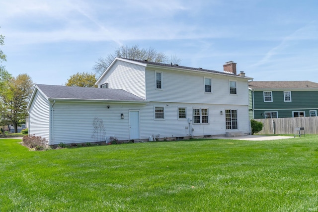 rear view of house featuring a patio, fence, a yard, and a chimney