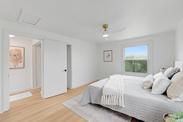 bedroom featuring ceiling fan, baseboards, attic access, and light wood-style floors