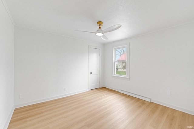 empty room featuring ceiling fan, crown molding, light wood-type flooring, baseboards, and a baseboard radiator