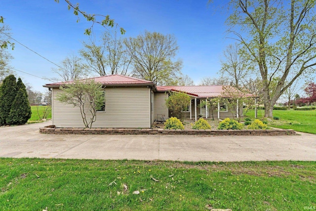 ranch-style home with metal roof and a front lawn