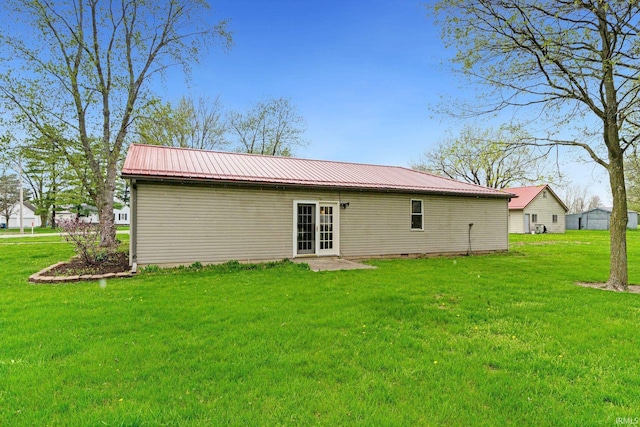 back of house with a yard and metal roof