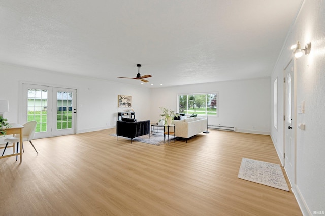 living room featuring light wood-style floors, baseboards, a baseboard radiator, and a ceiling fan