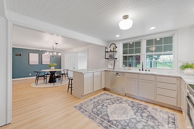 kitchen with a notable chandelier, light stone counters, light wood-style floors, dishwasher, and a peninsula