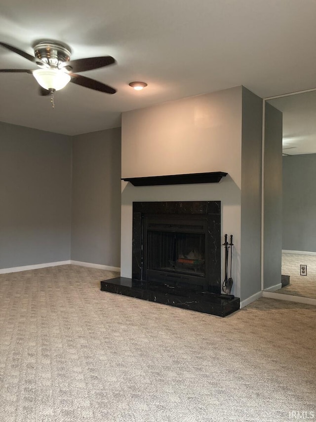 unfurnished living room with baseboards, carpet flooring, ceiling fan, and a fireplace