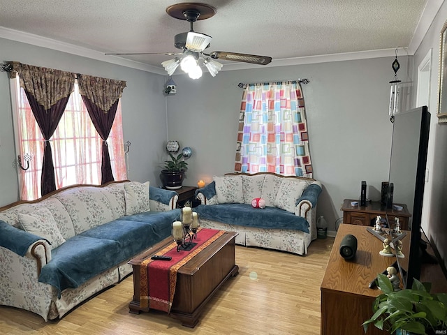 living area featuring a textured ceiling, ceiling fan, ornamental molding, and light wood-style floors