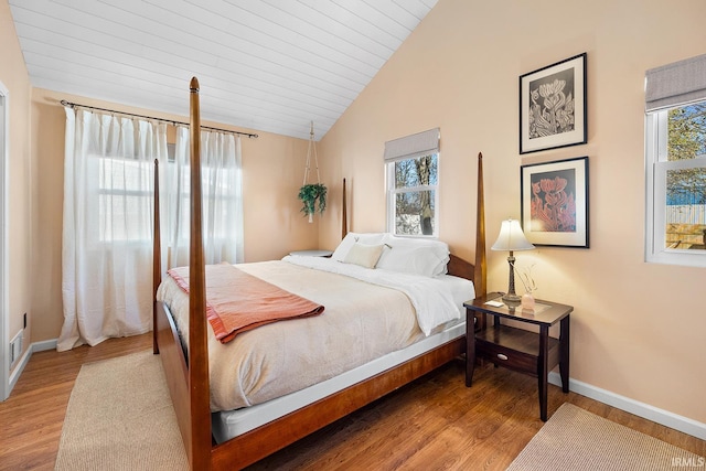 bedroom with baseboards, vaulted ceiling, wooden ceiling, and wood finished floors