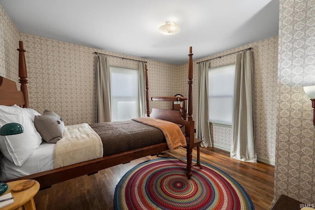 bedroom with wallpapered walls and wood finished floors