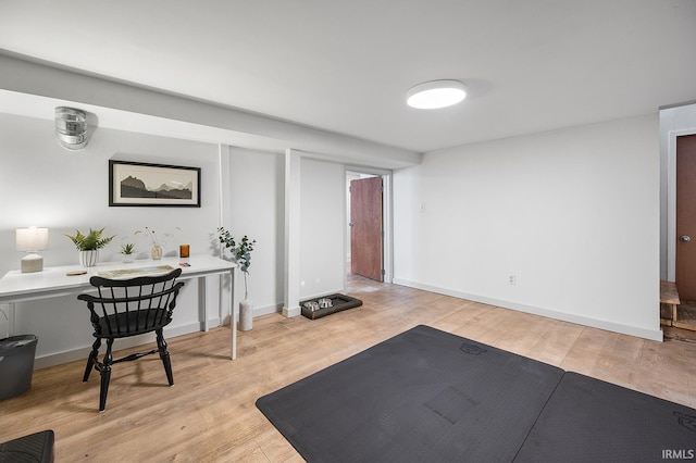 workout room with baseboards and wood finished floors