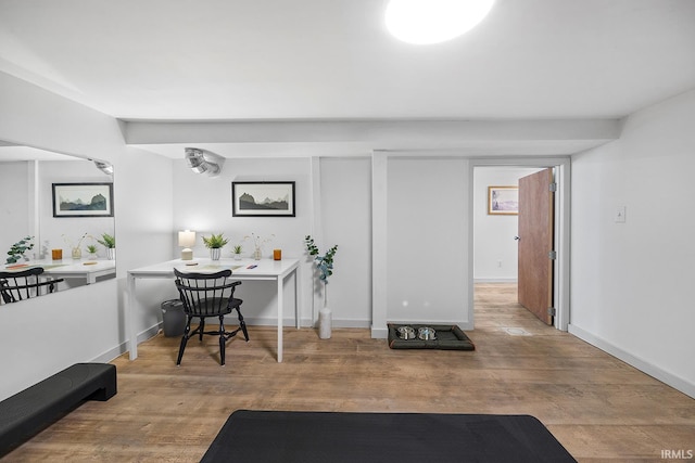 workout room with baseboards and wood finished floors
