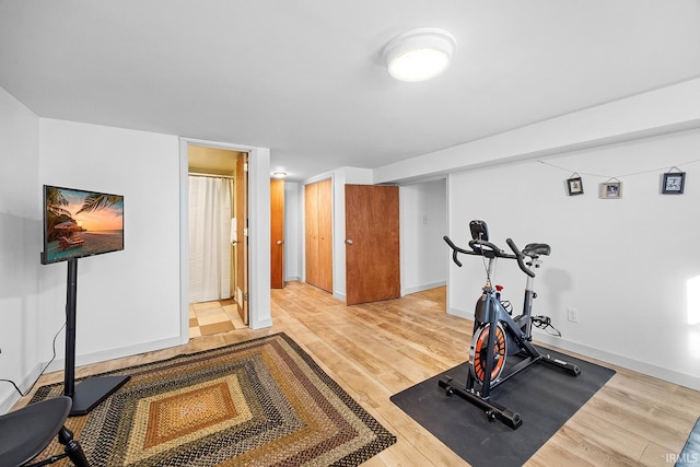 exercise area featuring baseboards and light wood-style flooring