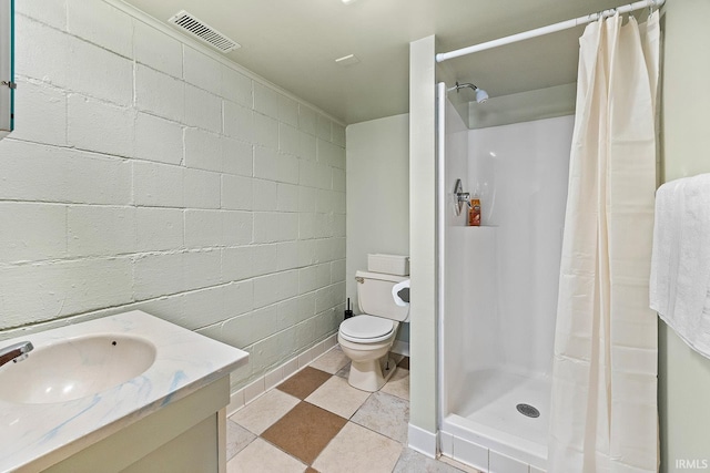 full bath featuring vanity, concrete block wall, toilet, visible vents, and a stall shower