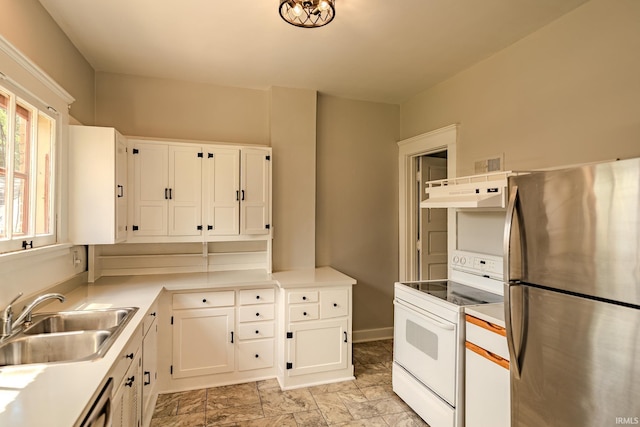kitchen featuring a sink, freestanding refrigerator, white electric range oven, under cabinet range hood, and white cabinetry