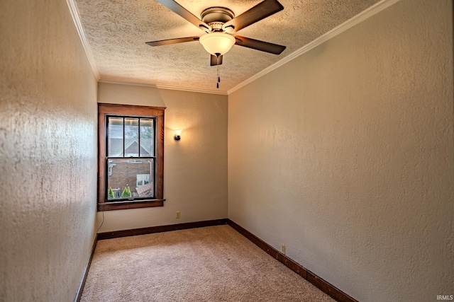 carpeted empty room with a ceiling fan, a textured ceiling, ornamental molding, and baseboards