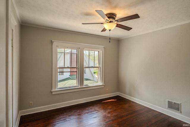 spare room with baseboards, visible vents, and dark wood finished floors