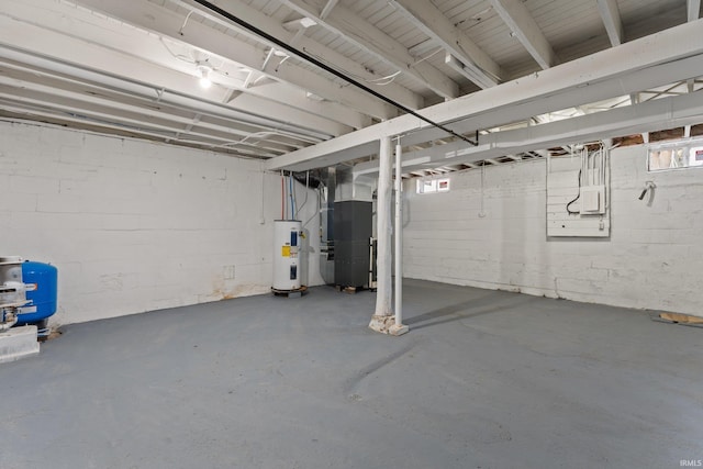unfinished below grade area featuring concrete block wall, heating unit, and electric water heater