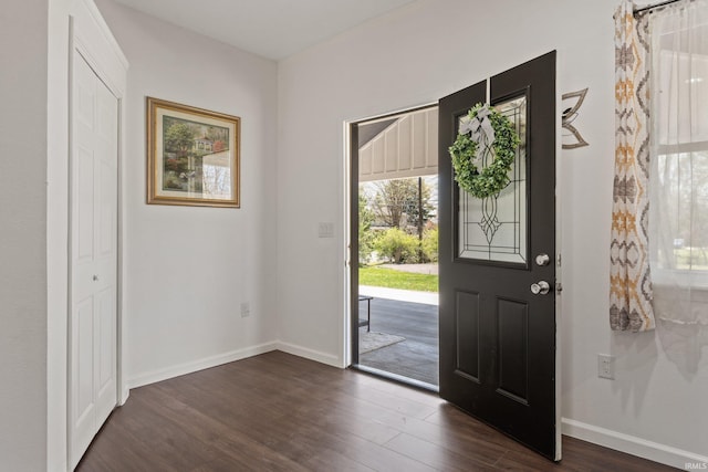 foyer featuring baseboards and dark wood-style floors