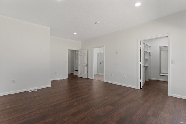 interior space with baseboards, recessed lighting, dark wood finished floors, and visible vents