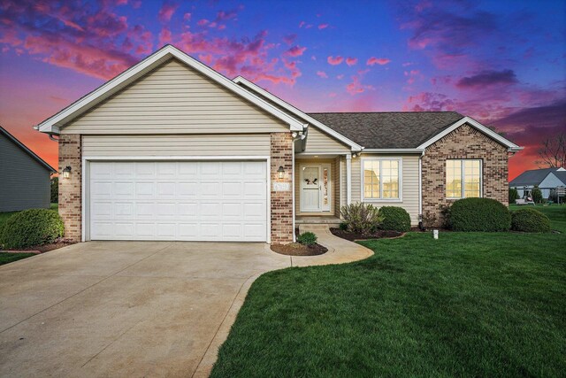 ranch-style home with a lawn, concrete driveway, and brick siding
