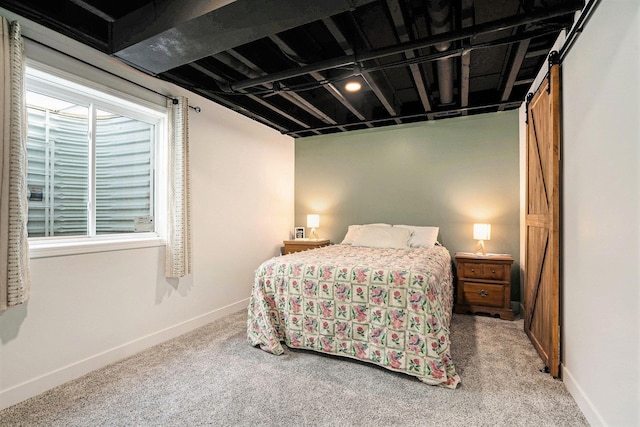 bedroom featuring baseboards, a barn door, and carpet