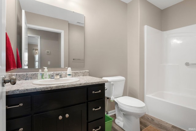 bathroom with visible vents, wood finished floors, vanity, toilet, and washtub / shower combination