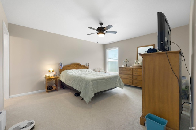 bedroom with a ceiling fan, baseboards, and light carpet